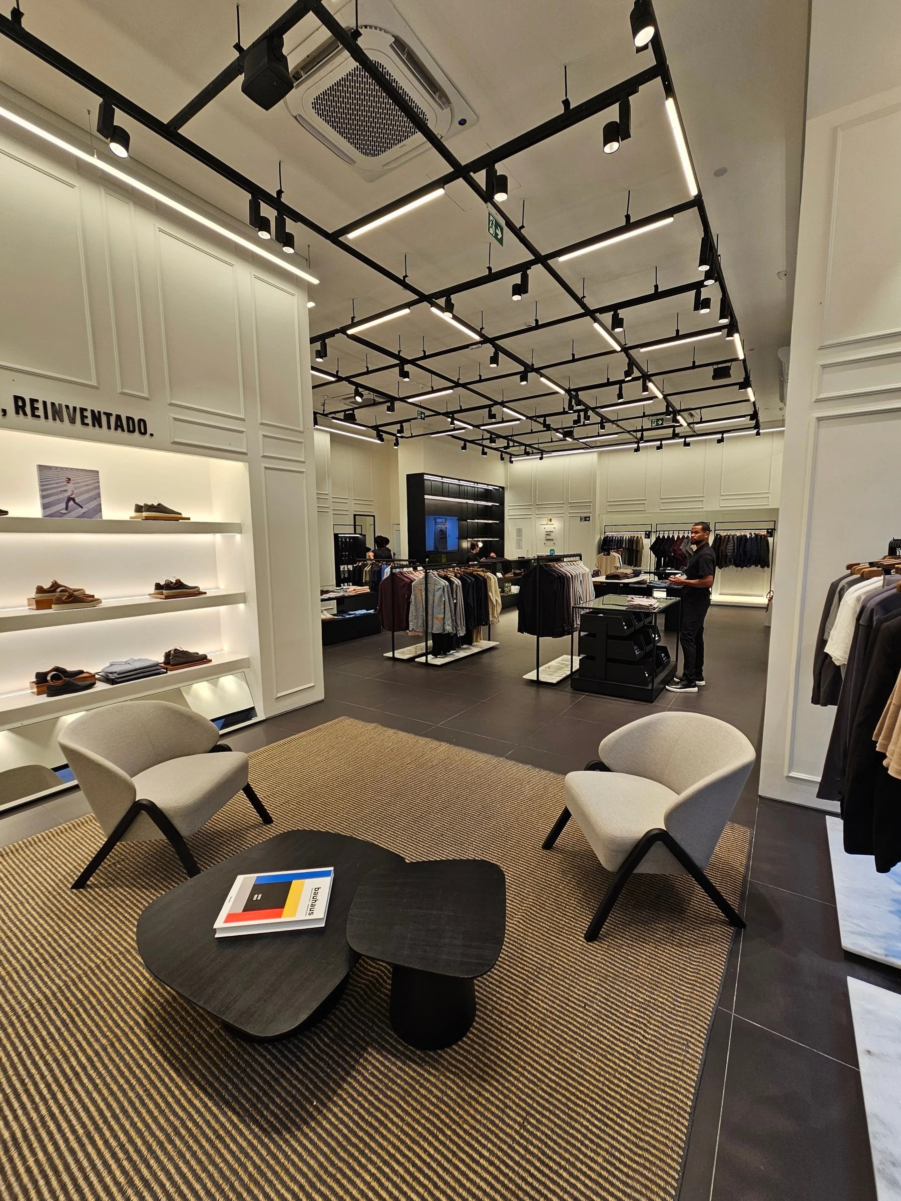 Magasin aménagé avec présentoirs, éclairage et espace central pour accueillir les clients