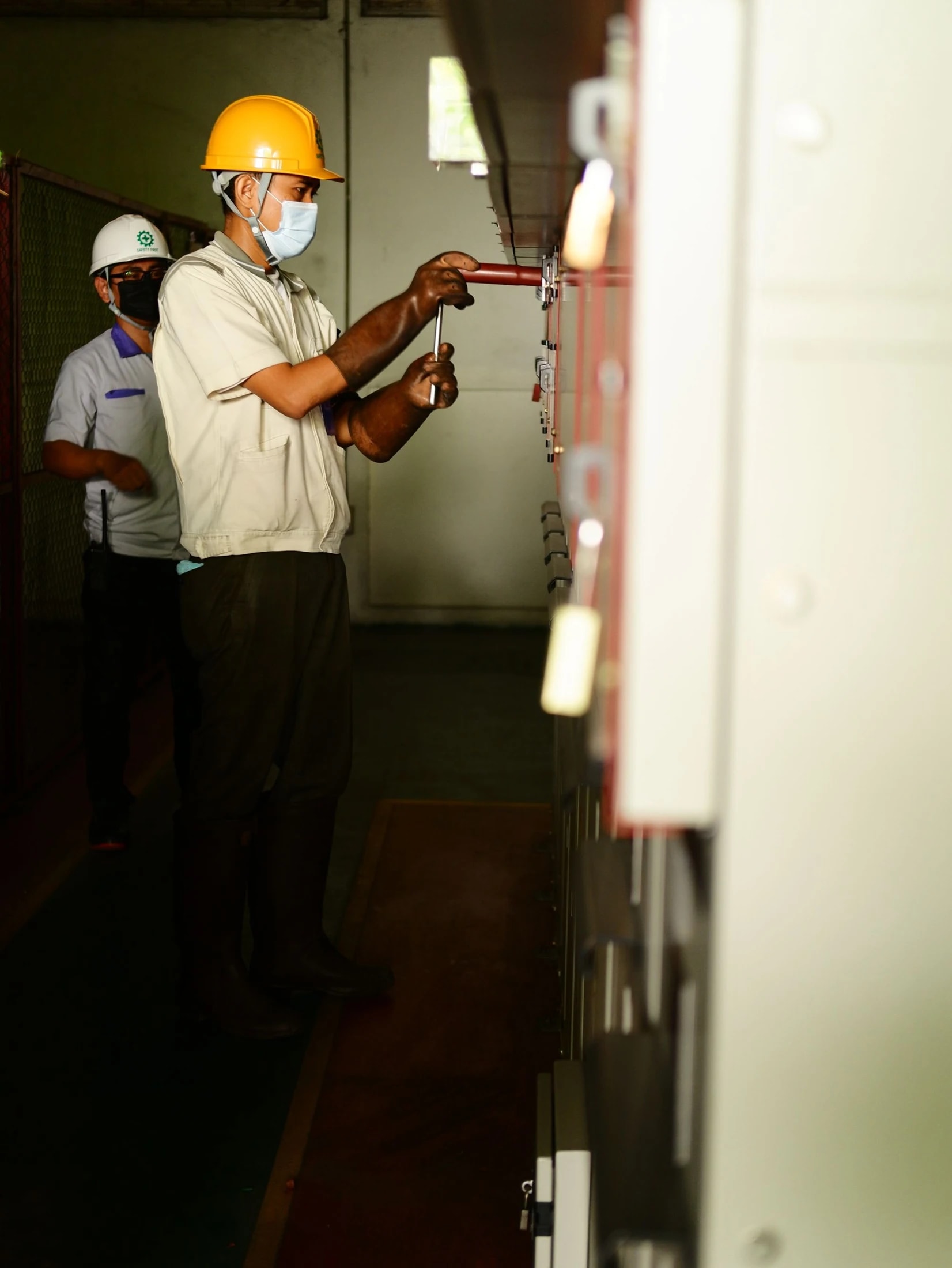 Techniciens intervenant sur une armoire électrique dans un local technique