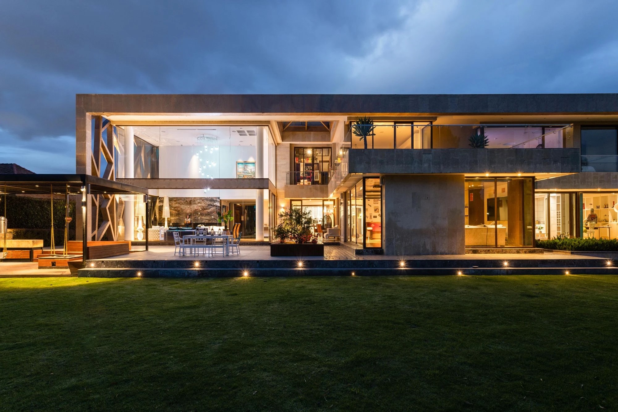 Façade contemporaine éclairée avec volumes, parements et grandes ouvertures