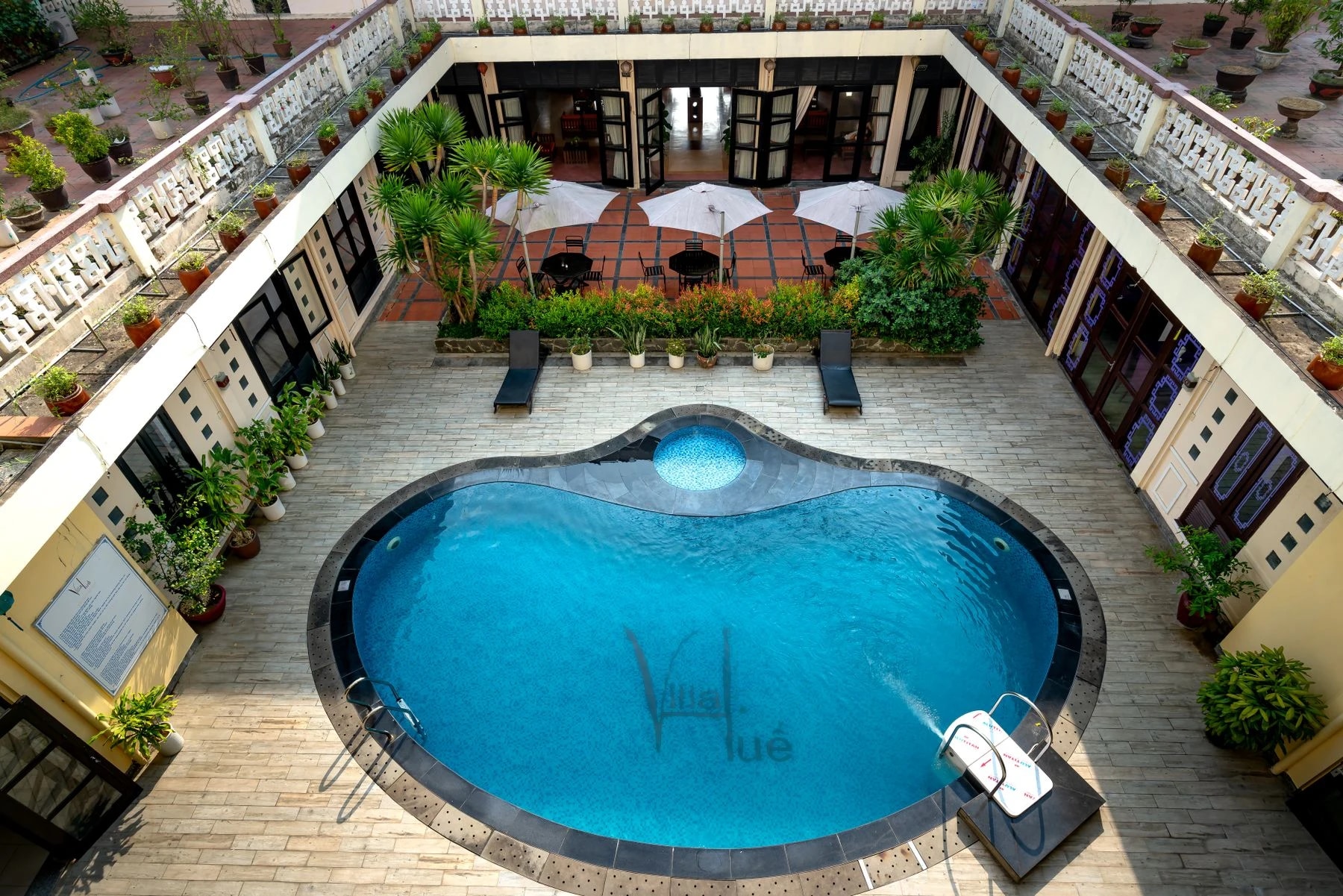 Cour d’hôtel avec piscine et espaces de détente