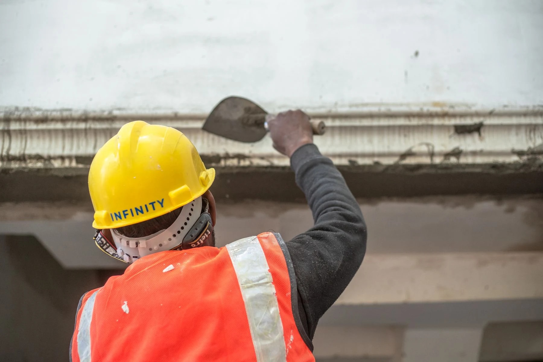 Professionnel appliquant un enduit à la truelle en intérieur