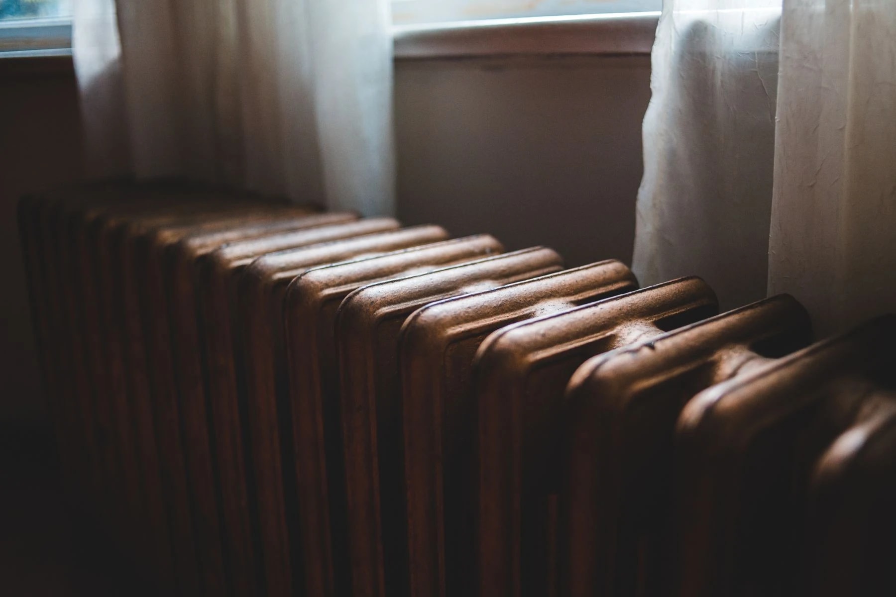 Radiateur en fonte près d’une fenêtre, photographie d’ambiance